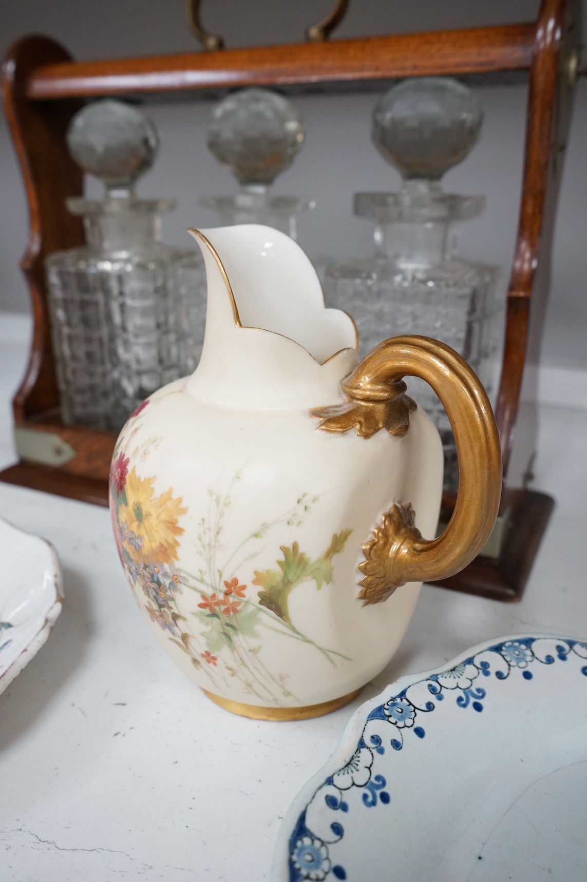 An oak three bottle tantalus, with key, together with three 18th/19th century faience plates and a Royal Worcester jug, tantalus 36cm wide
